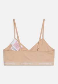 Beige Converse bralette laget av myk stoff, med justerbare stropper, v-halsdesign og en kontrastfarget hvit logo-bånd.