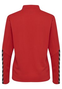 Camicia rossa a maniche lunghe con tessuto texturizzato, dotata di colletto alto e dettagli a strisce nero e bianco sulle maniche.