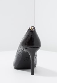 Escarpin noir à talon haut avec motif crocodile, bout pointu et accent doré à l'arrière. Texture lisse et brillante, avec un talon aiguille surélevé.