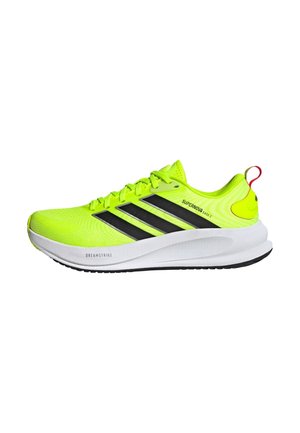 Neongele hardloopschoen met zwarte Adidas-strepen, witte zool met de opdruk "Dreamstrike" en de tekst "Supernova Ease 2" aan de zijkant.