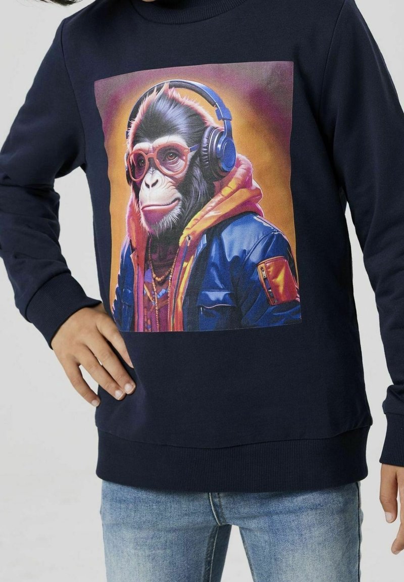 Marineblaues Sweatshirt mit einem Grafikdesign eines Affen, der Kopfhörer und einen bunten Kapuzenpullover trägt, mit gerippten Bündchen und Saum. Baumwollmischgewebe.