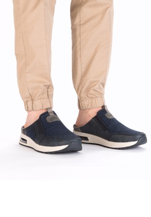Baskets navy à enfiler, fabriquées en maille respirante et en daim, dotées d'une semelle en caoutchouc et d'une semelle intermédiaire de couleur claire avec un accent gris.