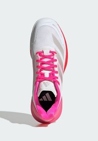 Białe buty sportowe z różowymi sznurówkami i akcentami. Posiadają siateczkową cholewkę, wyściełany kołnierz i teksturowaną podeszwę. Logo Adidas na języku i podeszwie.