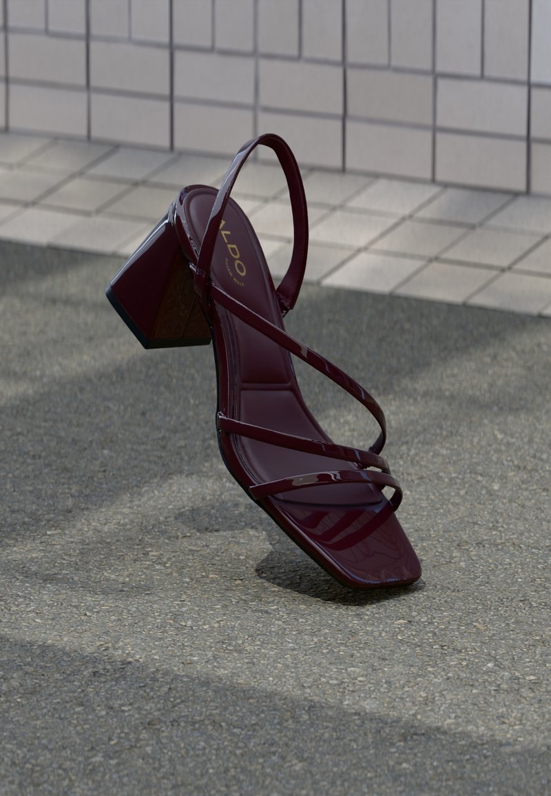 Bordo sandala s visokim potpeticama i sjajnim lakiranim završetkom, s više tankih remenčića i dizajnom kvadratnog vrha. Debela kvadratna potpetica.