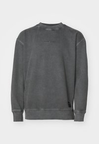 Felpa grigia realizzata in misto cotone, con scollo tondo, polsini a coste e logo ricamato "TOMMY JEANS" sul petto.
