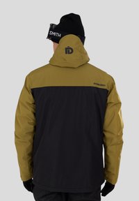 Voděodolná lyžařská bunda v olivově zelené a černé barvě. Obsahuje kapuci, zesílené švy a branding na zadní straně. Hladká, strukturovaná tkanina.