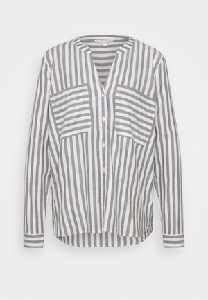 Chemise à manches longues boutonnée avec des rayures verticales grises et blanches et deux poches poitrine avec des rayures horizontales.
