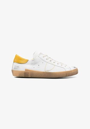 Baskets en cuir blanc avec un talon jaune et une semelle en caoutchouc beige. Présentent des accents cousus et un design à lacets. Semelle extérieure texturée.
