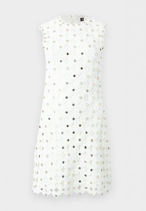 Robe blanche sans manches avec motif en dentelle florale et petits œillets métalliques ronds répartis uniformément sur le tissu.