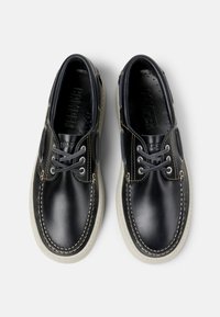 Schwarze Lederschuhe mit hellen Gummisohlen, runder Zehenform, kontrastierendem Nähten und Schnürung.