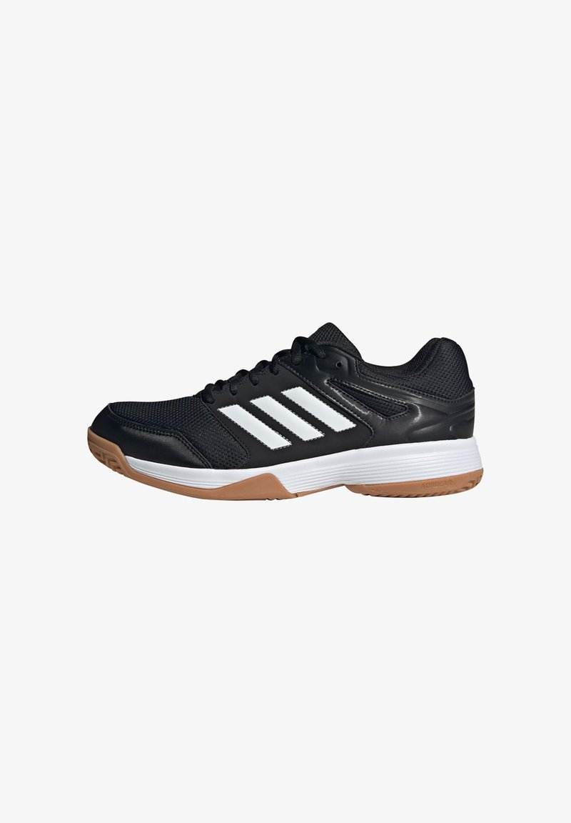 Chaussure de sport noire avec des bandes blanches, une semelle intermédiaire blanche et une semelle extérieure en caoutchouc brun clair, conçue pour une utilisation en intérieur.
