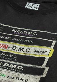 Next LICENSE REGULAR - Nyomott mintás póló - black run dmc