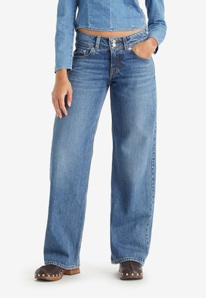 Jeans de tiro alto de color azul claro y corte wide-leg, fabricados en denim. Cuenta con cierre de botón, pasadores para cinturón y bolsillos frontales.