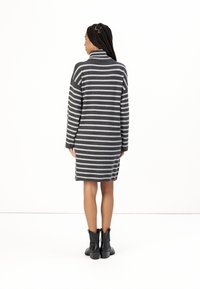 Robe pull rayée en gris et noir, dotée d'un col montant, de manches longues et d'une coupe décontractée, se terminant au-dessus des cuisses.