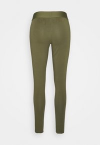 Olivi vihreät legginsit, joissa on sileä pinta, tiukka leikkaus ja leveä vyötärö. Kangas näyttää joustavalta ja vartalonmyötäiseltä.