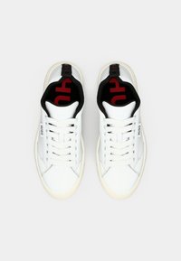 Białe sneakersy z gładką skórzaną cholewką, czarnym wnętrzem i czerwonym logo. Posiadają płaskie sznurówki oraz gumową podeszwę.