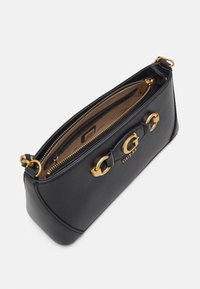 Černá kožená kabelka se zlatými detaily, která má logo "G", zipové uzavírání a hladký povrch. Interiér je podšitý krémovou látkou.