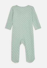 Green cotton onesie with long sleeves, featuring a white heart pattern, round neckline, and snap closure at the bottom.