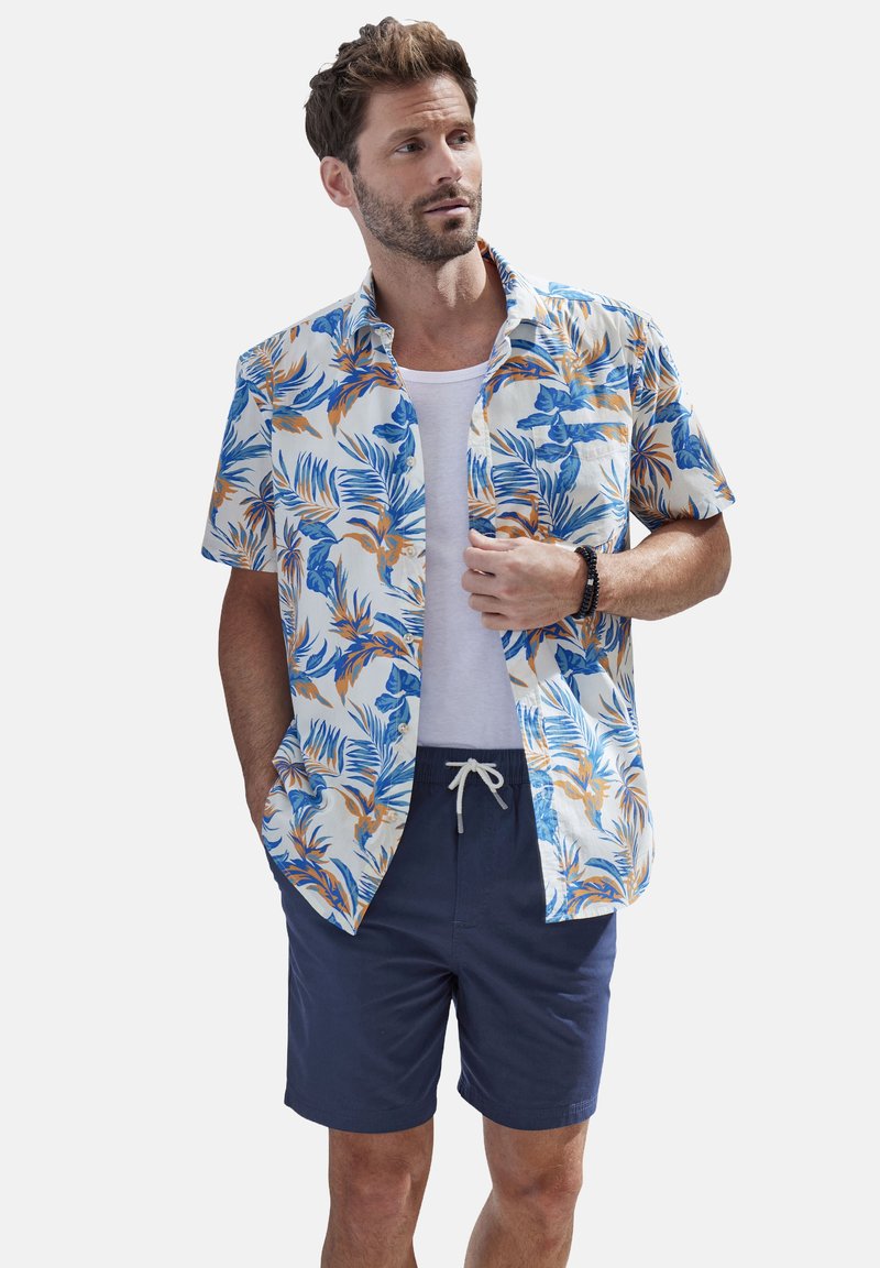 Short-sleeve, button-up shirt featuring a blue and orange tropical leaf pattern on a white background, paired with navy shorts.