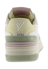 Sneaker con tacco in tonalità crema, giallo chiaro, verde e rosa con logo ricamato e testo "1985" sopra la suola texture.