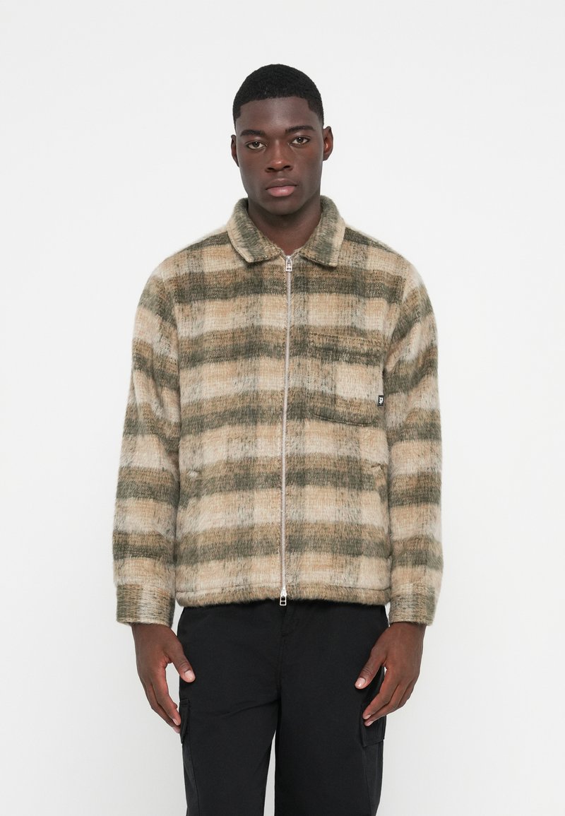 Plaid zip-up jacket in beige and green tones, featuring a soft texture and a collared neckline, with side pockets and ribbed cuffs.