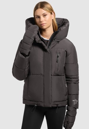 Ullig, mörkgrå jacka med stor huva, dragkedja fram i fickan och elastiska ärmar. Har ett texturerat tyg och snörning i nederkant.