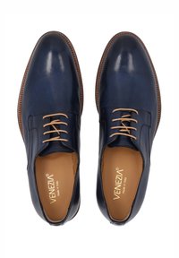Marine leren schoenen met een gladde afwerking, ronde neus en beige veters. Beschikt over een bruin gestikt rand en een gedeputeerde binnenkant.