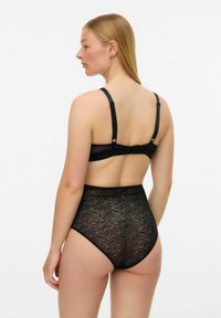 Melna apakšveļas komplekts ar caurspīdīgu, teksturētu krūšturi un augsta vidukļa biksītēm ar viļņotu rakstu. Regulējamas lencītes un aizdare ar āķi.