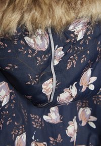 Navy floral jacket featuring pink and white flower patterns, herringbone texture, grey piping, and a faux fur trim around the hood.
