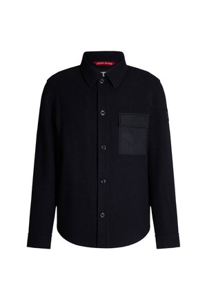 Black wool shirt jacket featuring a button closure, collar, and a distinctive chest pocket made of a smooth fabric.