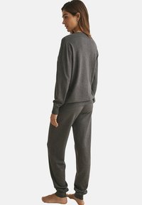 Grijze gebreide trui en broek set, met een geribbelde halslijn en manchetten, in een ontspannen pasvorm en zachte textuur. Geen zichtbare patronen of hardware.