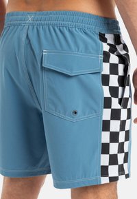 Blaue Badeshorts mit Karomuster an der Seite, mit einer Gesäßtasche und elastischem Bund. Hergestellt aus leichtem Material.