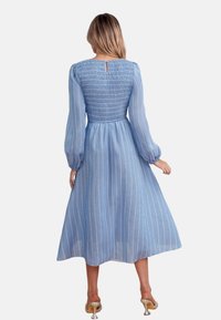 Vestido midi azul a rayas con corsé fruncido y mangas largas, que presenta un detalle de escote en forma de llave en la parte trasera y una falda fluida.