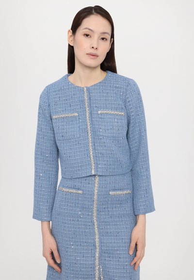 Hellblaues Tweed-Jackett mit langen Ärmeln, zwei vorderen Taschen und metallischen Akzenten. Strukturierter Stoff mit taillierter Passform und rundem Ausschnitt.