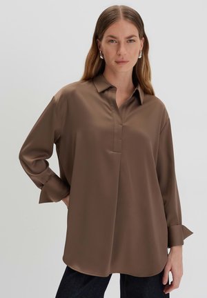Brown, long-sleeve blouse with a button-down collar, soft texture, and subtle front placket. Features cuffed sleeves for a relaxed fit.