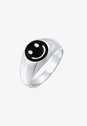 Sølvring med en sort cirkulær overflade, der har et hvidt smiley ansigt design, poleret finish og en glat, afsmalnet band.