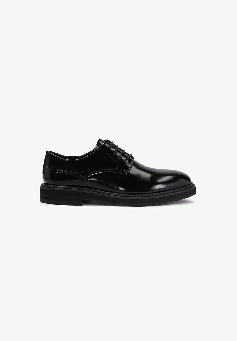 Chaussure habillée noire en cuir brillant à lacets, semelle épaisse, petit talon et bout arrondi, vue de côté extérieure sur fond blanc.