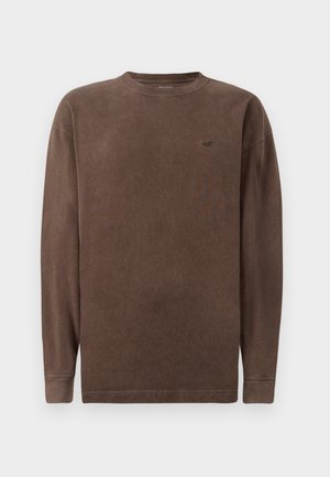 Brun langærmet t-shirt lavet af blødt stof, med rund hals og subtilt logo på brystet. Enkel design med syninger.