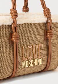 Brunnet flettet håndveske med faux fur-detaljer, med flettede skinnhåndtak og logo i gulltone "LOVE MOSCHINO". Teksturert overflate og elegant design.