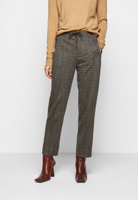 Pantalons tailleur à carreaux en gris, marron et noir, dotés d'une taille élastique et d'un cordon de serrage, associés à des bottines à talons marron.