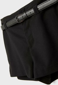Pantaloni corti neri su misura con una cintura nera in pelle slim che presenta una fibbia rettangolare argentata, su uno sfondo neutro.