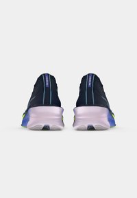 Para czarnych butów do biegania Nike z fioletowymi podeszwami, pokazana z tyłu na białym tle.