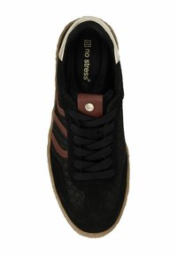 Black suede sneaker with brown leather accents, textured surface, round toe, and flat black laces. Features a brown logo plate and gum sole.