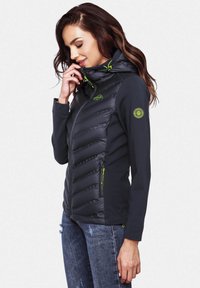 Black, puffer-style jacket with a hood, featuring green accents, zippered pockets, and a streamlined fit with textured detailing.