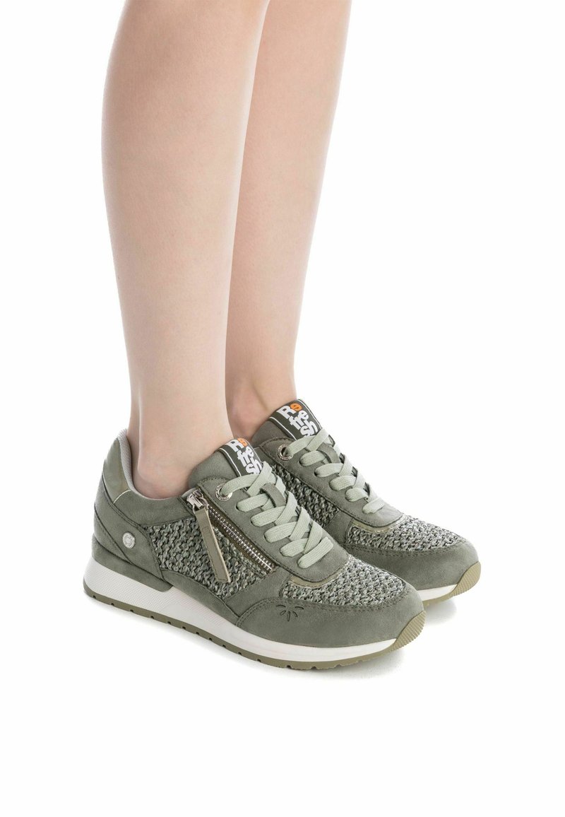 Zapatillas de ante verde con paneles de punto texturizado, diseño con cordones, cremallera lateral, suela blanca y oliva, y acentos de logo en la lengüeta.