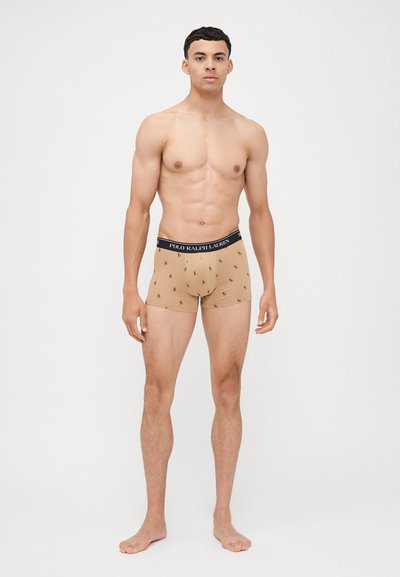 Boxer in colore beige con elastico nero "Polo Ralph Lauren", caratterizzati da piccoli loghi ricamati neri. Tessuto morbido, design aderente.