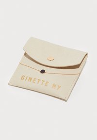 Bežna filcova kartica s poklopcem, zlatim gumbom na klik in vtisnjenim besedilom "GINETTE NY". Preprost oblik s šivanjem.