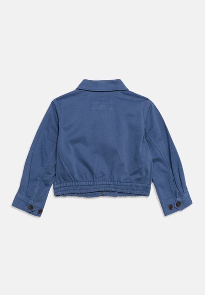 Μπλε cropped σακάκι με μακριά μανίκια, κουμπωτά μανίκια και ελαστική μέση, εμφανίζεται από πίσω σε λευκό φόντο.