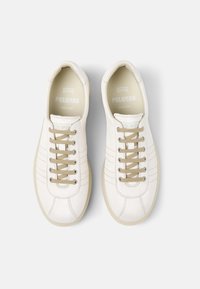 Sneakers bianchi in pelle con lacci beige, caratterizzati da sottili dettagli di cucitura e una punta arrotondata. Il marchio è visibile sulla linguetta.