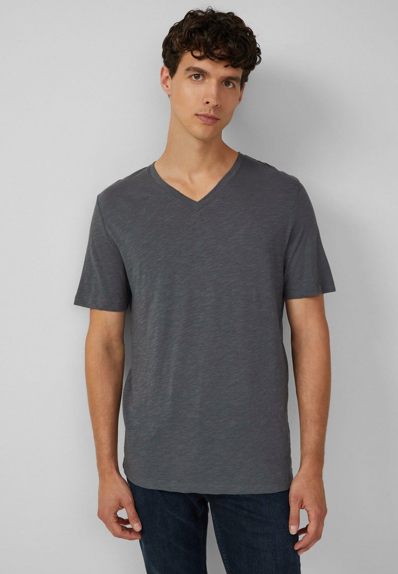 Szara krótko rękawowa koszulka typu V-neck, wykonana z lekkiej, teksturowanej tkaniny. Luźny krój z gładkim wykończeniem i subtelnym wzorem melanżowym.